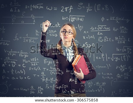 Student girl writing formulas on transparent wall front her