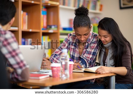 Couple of female students studying for exam after lecture in college