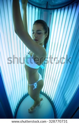 Pretty woman standing  in tanning booth