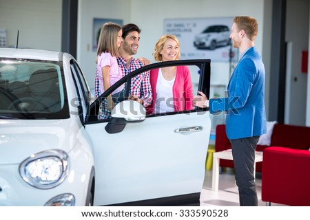 Cheerful family in car showroom in car showroom