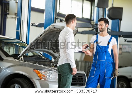 Customer giving him car keys to mechanic in service