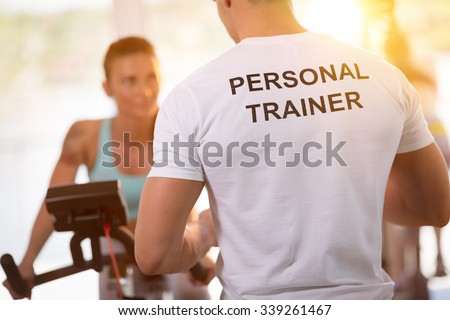 Personal trainer on weights lifting training with  client