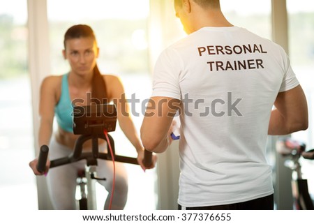 Personal trainer at the gym with client on bike
