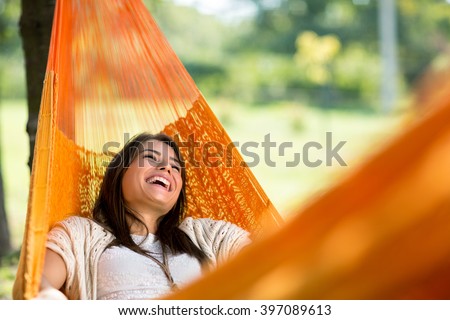 Cheerful girl enjoy in orange hammock outdoor
