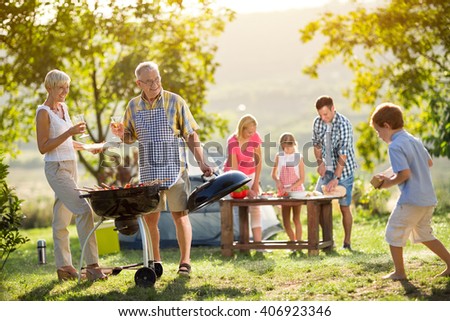 Happy family camping and cooking bbq