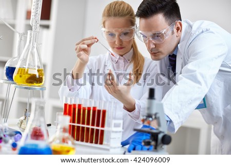 two student looking at a microscope slide in a laboratory