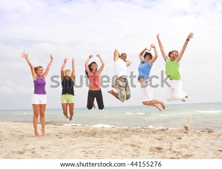 jumping group of happy people by the sea
