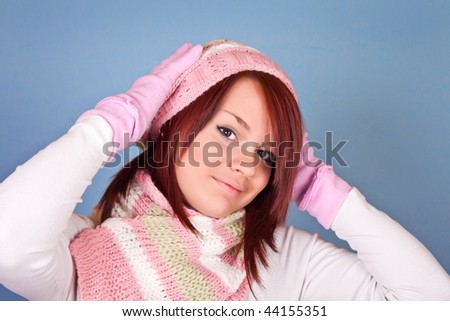 beautiful girl in scarf and hat holding her head