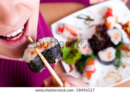 close-up of young  woman eating sushi  front view
