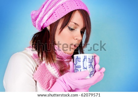 cute girl blows her tea on blue background