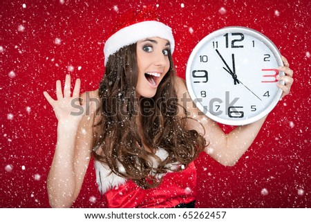 excited santa girl holding clock while snowing