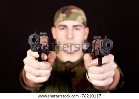 stock-photo-modern-young-soldier-with-two-guns-pointed-at-the-camera-76210117.jpg
