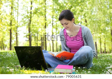 young student girl with laptop learning in park
