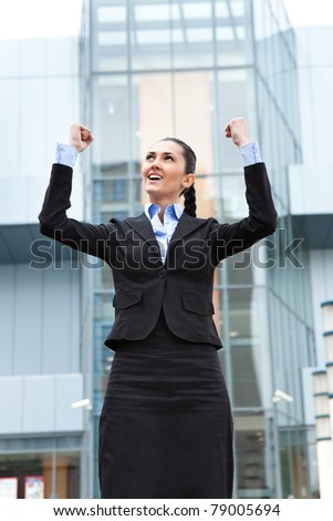 businesswoman standing outdoor  celebrating her winning, front office bulding