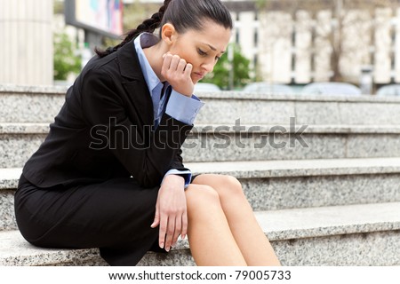 businesswoman sitting on the stairs of the company troubled after getting the news he was fired