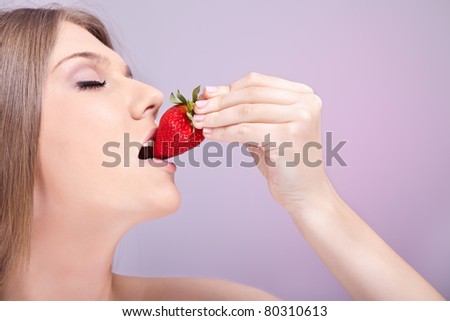 sensual young woman biting strawberry, enjoying in  bite