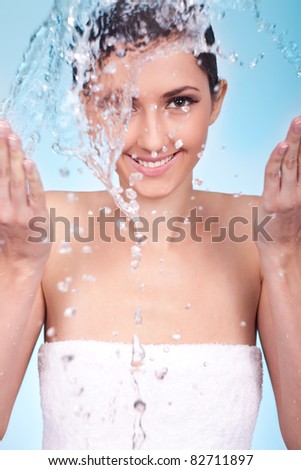 smiling woman playing with water, washing her face