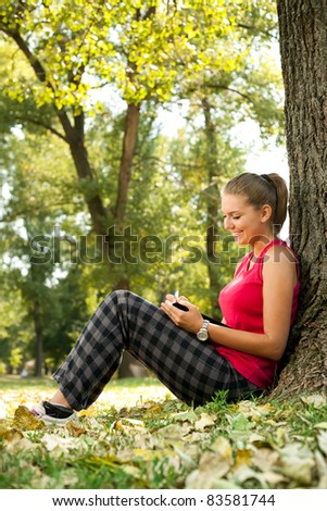 student girl sitting in park and writing in notebooks