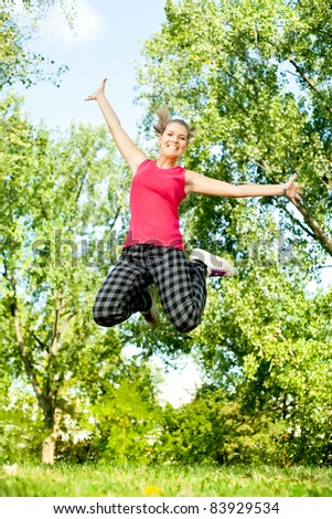young happy woman jumping in park