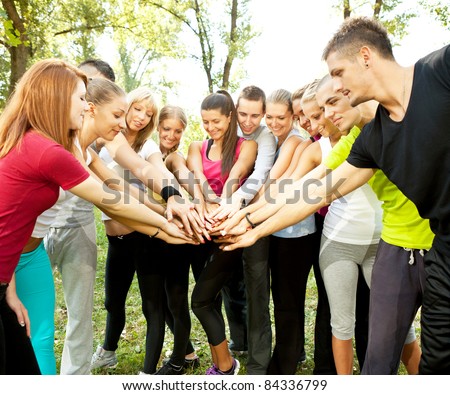 large group of young people with their hands together outdoor