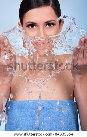 woman washing  her face with water, close up