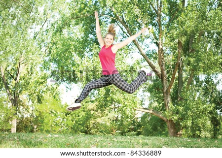 beautiful happy girl jumping outdoors in park