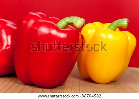 red and yellow peppers on red background