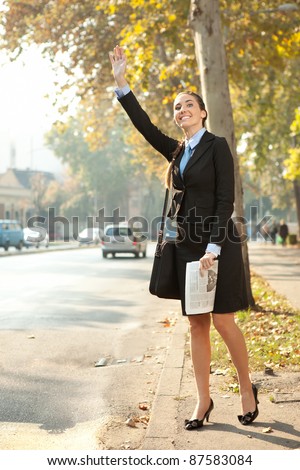 Business woman hailing  taxi cab in city