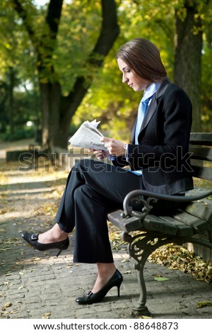 businesswoman reading newspaper on break,  outdoor