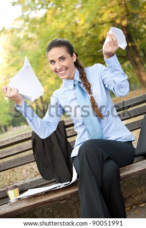 smiling businesswoman with  tear  documents in hands, outdoor