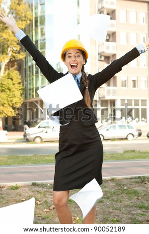 happiness female engineer celebrating her success, throwing paper in the air