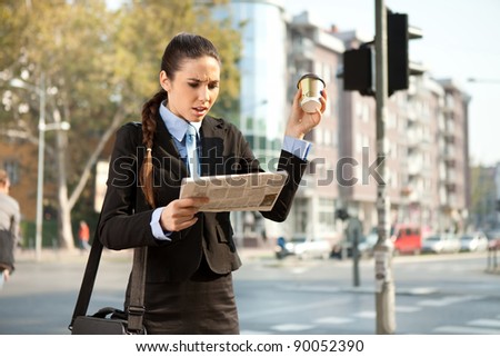 upset businesswoman reading bad news in newspaper, outdoor