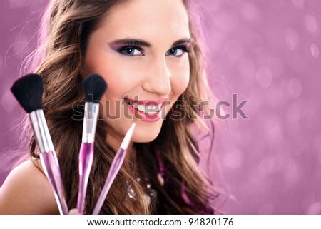 beautiful woman with make-up brushes near make-up face