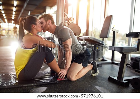 Fitness coach kiss girlfriend on training in gym