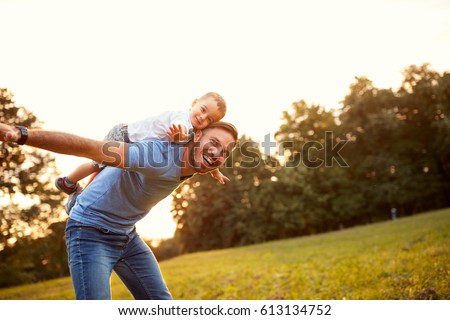 Father piggyback his little son outside