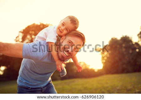 Father piggyback his little son outside