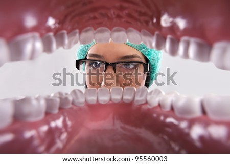 Female dentist over open patient\'s mouth looking in teeth