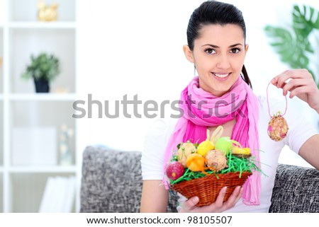 young woman holding a basket full of Easter eggs, smiling