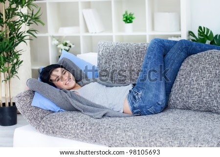Smiling woman enjoying on sofa, relaxation
