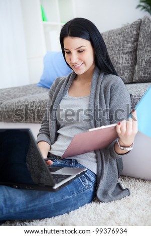 Young student girl with laptop learning for exam at home