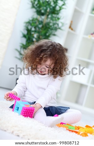 Child playing with cube toys, concentrate on connecting blocks