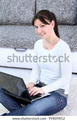 Cheerful young woman holding laptop in lap