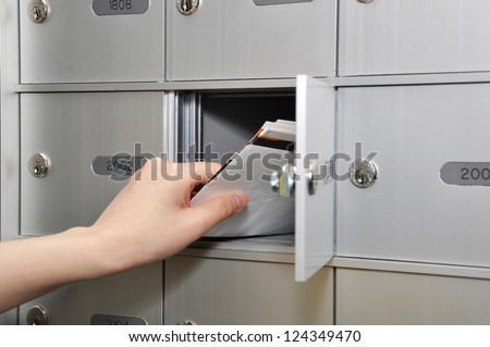 Woman taking some letters from mailbox