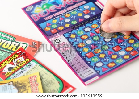 Coquitlam BC Canada - May 25, 2014 : Scratching lottery tickets. The British Columbia Lottery Corporation has provided government sanctioned lottery games in British Columbia since 1985.