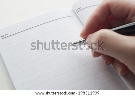 Close up woman\'s hand taking note