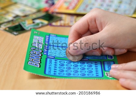 Coquitlam BC Canada - June 15, 2014 : Woman scratching lottery ticket called Bingo. It\'s published by BC Lottery Corporation has provided government sanctioned lottery games.
