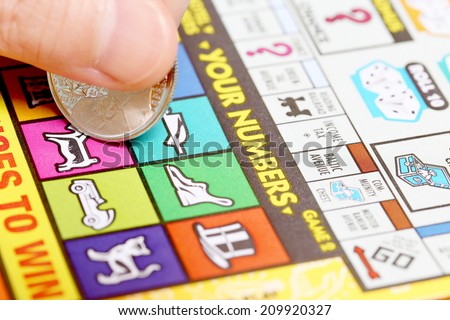 Coquitlam BC Canada - June 15, 2014 : Woman scratching lottery ticket. It\'s published by BC Lottery Corporation has provided government sanctioned lottery games.