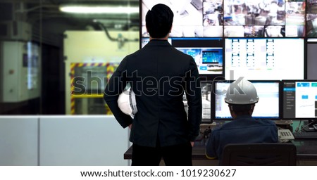 Process Control room and Industrial Automation in industry 4.0 technology trend concept. Engineer and director manager monitoring real time work automation machine process in smart factory.