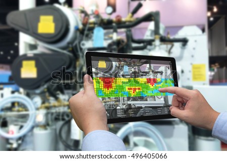 Augmented reality marketing and industry 4.0 concept. Hand holding tablet with AR screen application for measurement temperature machine in smart factory