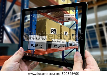 Industrial 4.0 , Augmented reality and smart logistic concept. Hand holding tablet with AR application for check order pick time in smart factory background